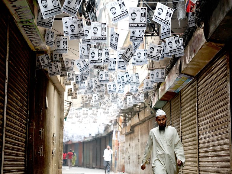 孟加拉国达卡，一名男子走过竞选海报。图片来源：路透社