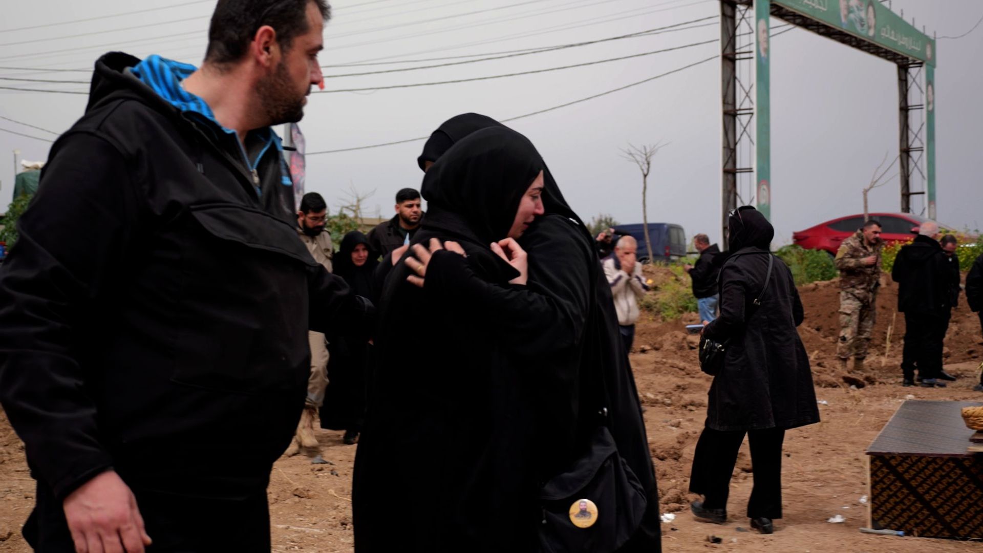 Some weep while others stare blankly ahead at a makeshift cemetery in Lebanon's evacuation zone