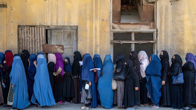 Afghan women wait for food rations. Image: AP