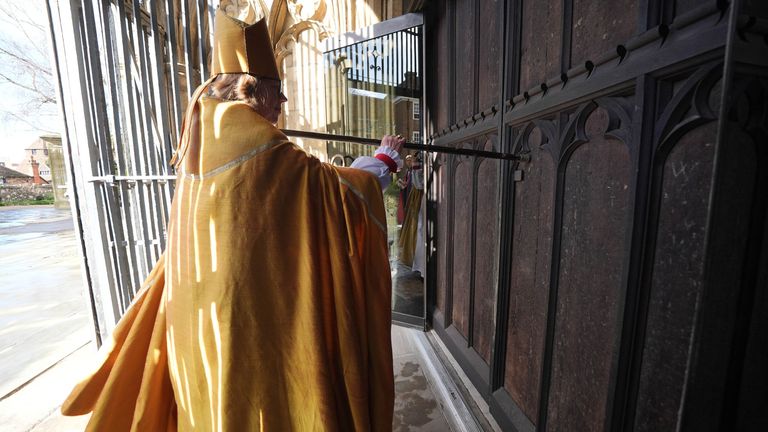 Dame Sarah Mullally strikes the west door of Canterbury Cathedral three times, as is tradition. Pic: PA