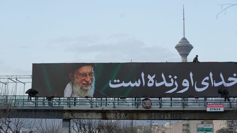 Workers install a billboard of the late Iranian Supreme Leader Ayatollah Ali Khamenei on 2 March. Pic: AP