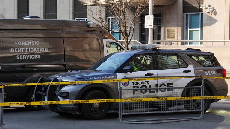 Police vehicles are parked by the US consulate after it was hit by gunfire in Toronto. Pic: AP