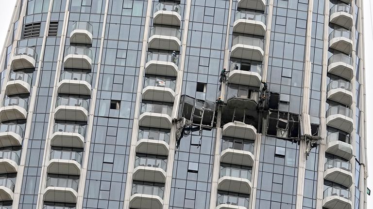 Workers inspect the damage caused by a drone strike overnight at the Address Creek Harbor Hotel in Dubai. Image: AP