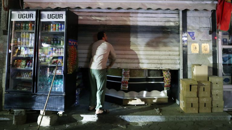 A man closing his shop due to earlier closing hours in Egypt. Pic: AP