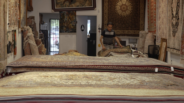 Luxury Persian rugs are stacked in piles in Eric Saddigh's Los Angeles shop