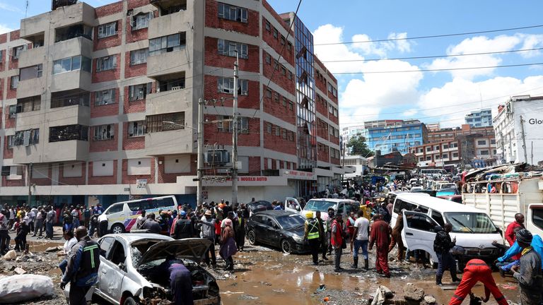 People stand around destroyed vehicles following flash floods in the Grogan area, popular for automotive workshops and secondhand spare parts. Pic: Reuters