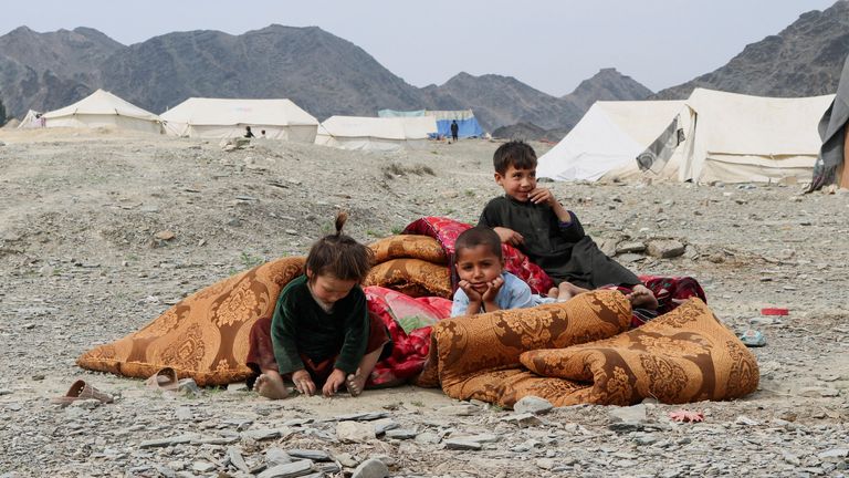 Displaced Afghan children sit outside their makeshift tent. Pic: Reuters