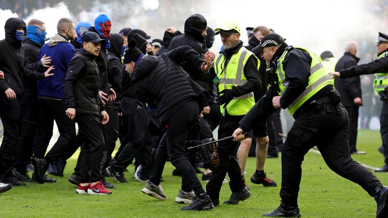 Police and stewards force fans back after the pitch invasion. Pic: PA