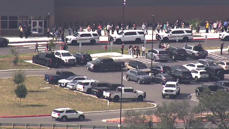 Parents line up to collect their children from a nearby middle school. Pic: WOAI/KABB