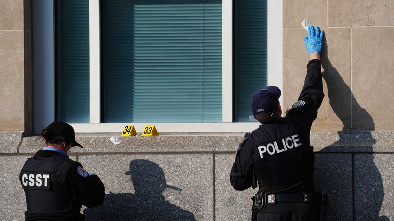 A forensic specialist marks bullet damage on the building. Pic: AP