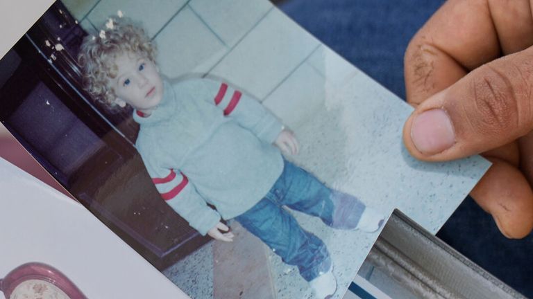 Khalid Ahmad holds childhood photos of his son, Walid Ahmad. Pic: AP