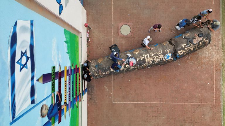 A drone view of children surrounding the projectile. Pic: Reuters