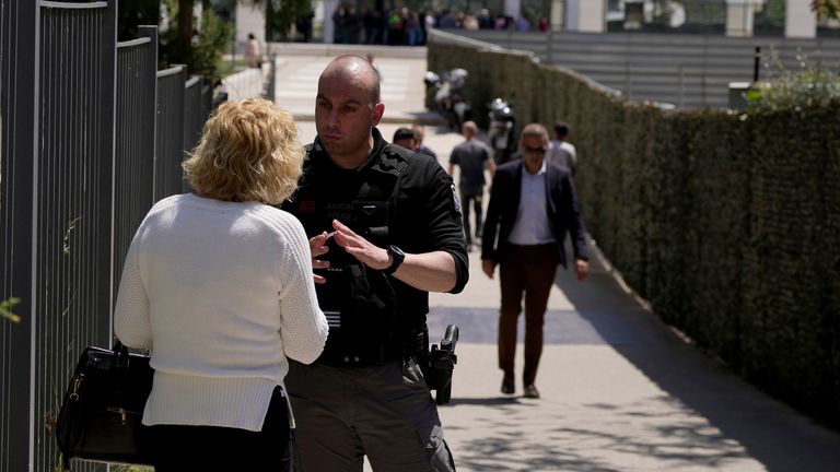 A policeman speaks with a woman outside the courthouse. Pic: AP