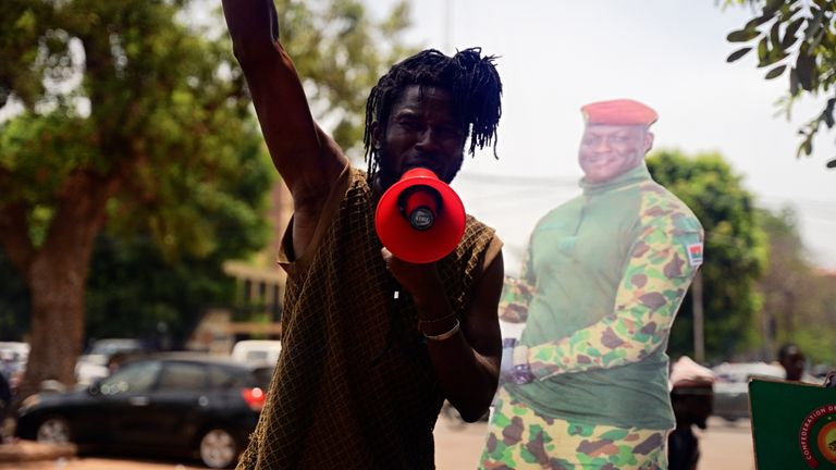 A man stands next to a cut-out of Traoré