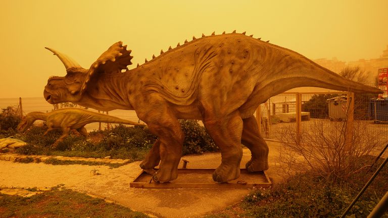 Sculptures of dinosaurs in Heraklion stand among the dust haze. Pic: Reuters
