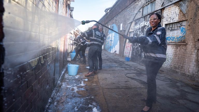 Ms Badenoch cleaning graffiti off a wall in Herne Hill, south London. Pic: PA