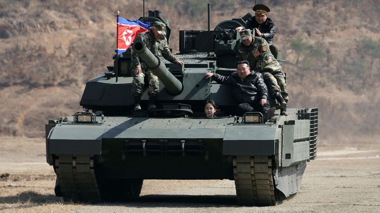 Kim Jong Un and his daughter are pictured on a tank at a military training base. Pic: AP