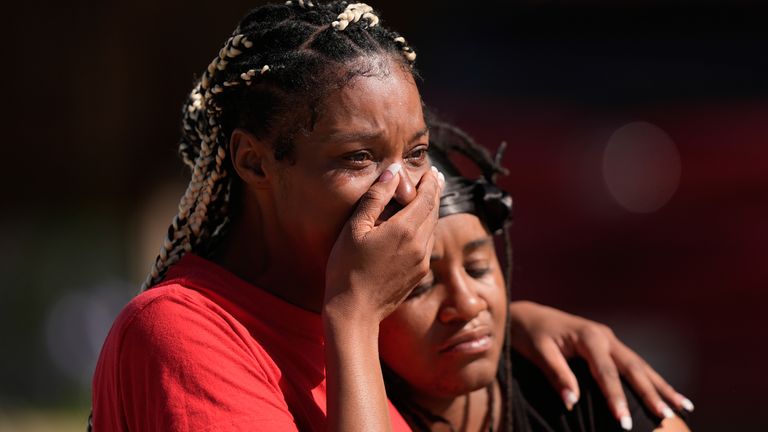 People comfort each other outside the scene of the shooting. Pic: AP Photo/Gerald Herbert