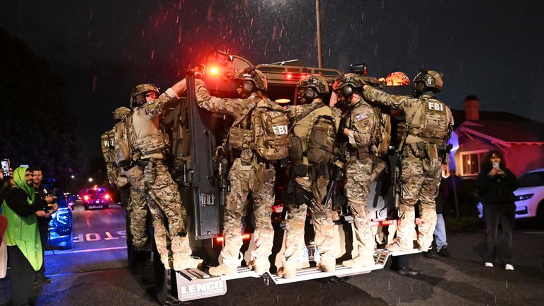 FBI personnel leave the scene. Pic: AP/William Lang