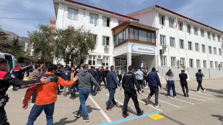 Police officers in uniform and plainclothes police secure the site after the shooting. Pic: IHA/Reuters