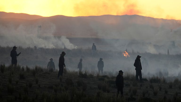 Protesters silhouetted against clouds of tear gas launched by police earlier this month. Pic: AP