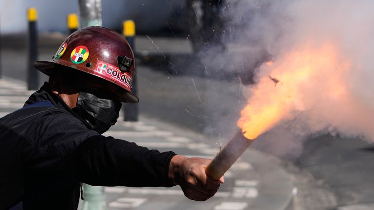 A miner launches a firecracker at police during the protest. Pic: AP