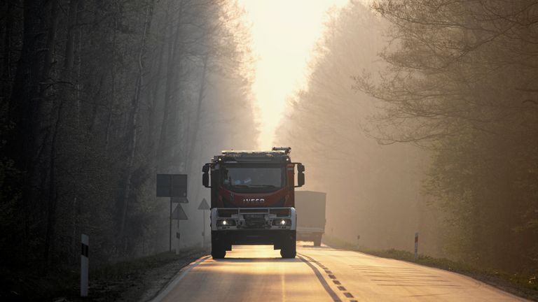 Smoke can be seen as a fire engine attends the forest fire. Pic: Agencja Wyborcza.pl/Reuters