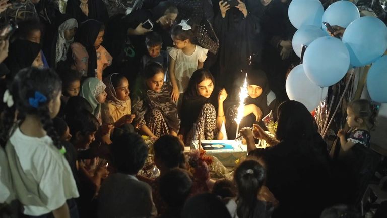 A cake is lit at the grave of one of the children who died