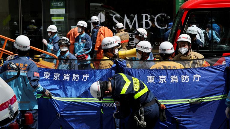 Emergency workers in hazmat suits and face masks were helping people at the scene. Pic: Reuters