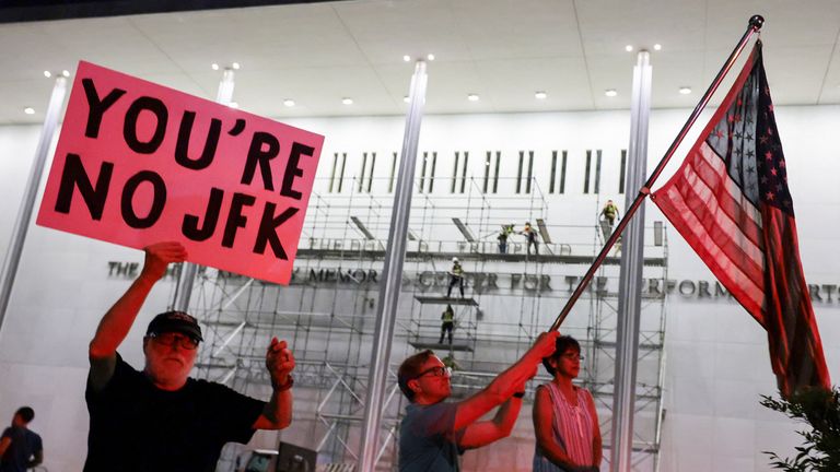 Protesters gather as scaffolders prepare to remove Trump's name. Pic: Reuters
