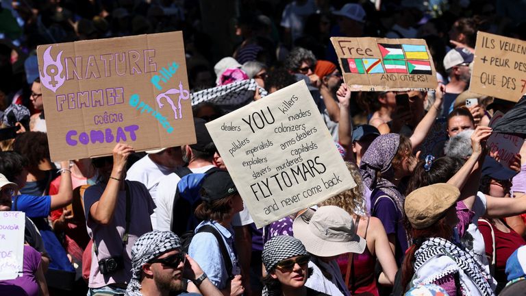 People hold signs during a protest against the upcoming G7 summit in Evian-les-Bains in France, in Geneva, Switzerland. Pic: Reuters