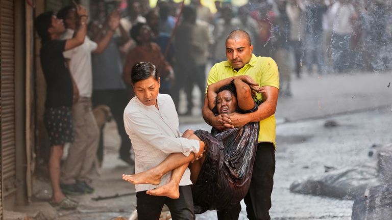 Local people rescue a person from the fire. Pics: AP