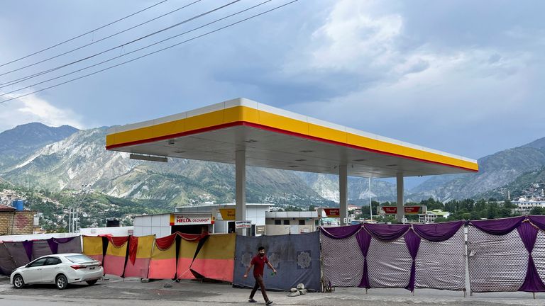 A man walks past a closed petrol station in Muzaffarabad. Pic: Reuters