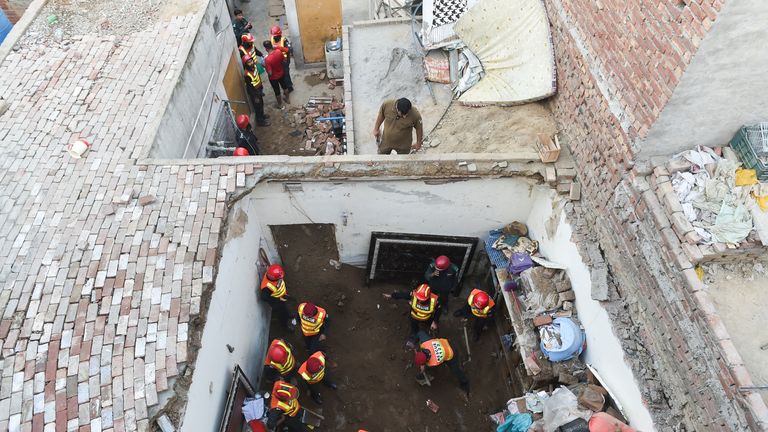 Rescue workers at the scene, searching through the debris. Pic: Reuters