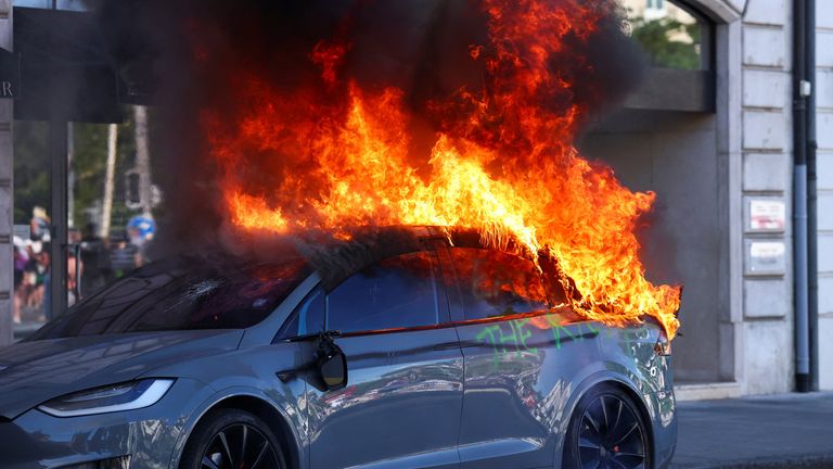 A Tesla car burns during a protest against the upcoming G7 summit in Evian-les-Bains in France, in Geneva, Switzerland. Pic: Reuters