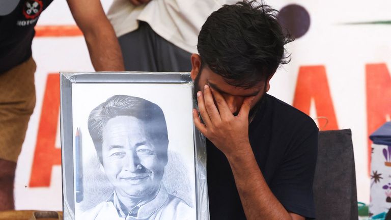 Abhijeet Dipke, head of the Cockroach Janta Party, holds a picture of Sonam Wangchuk. Pic: Reuters