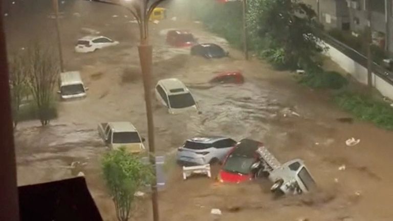 Vehicles are swept away by flooding in Hebei Province. Pic: Reuters