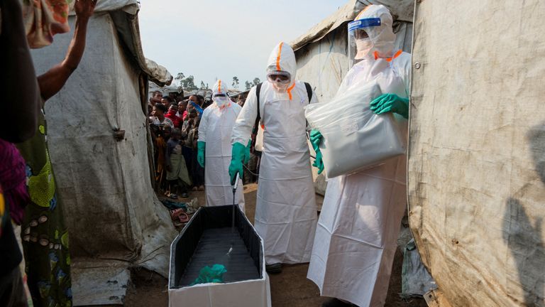Healthcare workers prepare for the burial of a suspected Ebola victim. Pics: Reuters