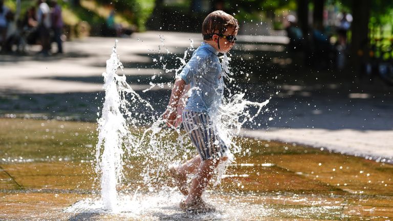 A boy cools down in fountain. Pic: PA