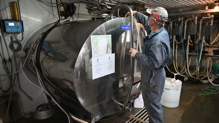 A farmer checks milk levels at a dairy farm in Quebec, Canada. Pic: Reuters