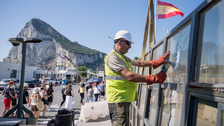 Against the backdrop of the Rock of Gibraltar, workers dismantle the border checkpoint. Pic: AP