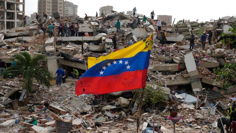 Residents and rescue workers search through the rubble in La Guaira. Pic: AP