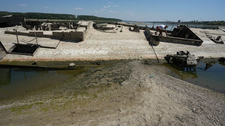 A man walks on the wreckage of a Nazi warship near Djerdap II, a large dam on the Danube River near Prahovo in Serbia. Pic: AP