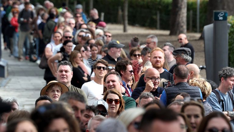 A queue of mourners gather to attend the star's wake in Dublin on Monday. Pic: PA