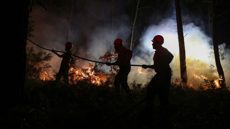 Firefighters work to extinguish a wildfire fanned by strong winds near Siviri, Greece. Pic: Reuters
