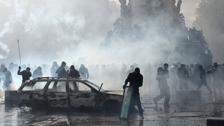 Masked protesters as police use tear gas amid clashes in Paris. Reuters